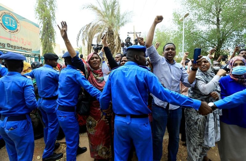 Sudanese police officers control civilians as they chant slogans outside the court during the new trial against ousted President Omar al-Bashir and some of his former allies on charges of leading a military coup that brought the autocrat to power in 1989 in Khartoum. Reuters