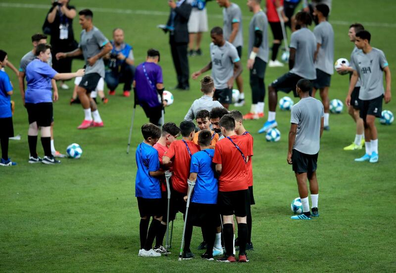 Young Liverpool fans get autographs from Mohamed Salah  on the pitch during the training session at Besiktas Park, Istanbul. PA Wire