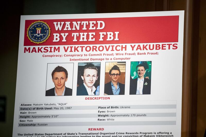 WASHINGTON, DC - DECEMBER 05: The wanted poster of Maksim Viktorovich Yakubets, also known as AQUA, who is one of two alleged Russian hackers that U.S. and U.K. Law enforcement officials announced warrants for their arrests at the U.S. Department of Justice on December 5, 2019 in Washington, DC. Today the U.S. Department of Justice, Federal Bureau of Investigations (FBI), and the U.S. Treasury Departments Office of Foreign Assets Control (OFAC) took action against Evil Corp, the Russia-based cybercriminal organization responsible for the development and distribution of the Dridex malware.  Samuel Corum/Getty Images/AFP
== FOR NEWSPAPERS, INTERNET, TELCOS & TELEVISION USE ONLY ==
