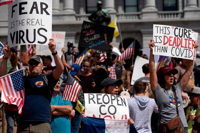 Demonstrators gather in front of the Colorado State Capitol building to protest coronavirus stay-at-home orders during a "ReOpen Colorado" rally in Denver, Colorado, on April 19, 2020. Hundreds protested on April 18 in cities across America against coronavirus-related lockdowns -- with encouragement from President Donald Trump -- as resentment grows against the crippling economic cost of confinement. / AFP / Jason Connolly
