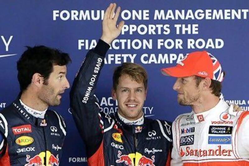 Red Bull driver Sebastian Vettel, centre, celebrates after taking pole position in qualifying for the Japanese Formula One Grand Prix, with teammate Mark Webber, left, who came in second and third placed McLaren driver Jenson Button, who qualified third but will start in eighth due to a grid penalty. Greg Baker / AP Photo