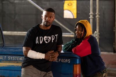 This image released by Netflix shows Jamie Foxx, left, and Dominique Fishback in a scene from "Project Power." The film, streaming Friday, imagines a world where a pill can give temporary superpowers. (Skip Bolen/Netflix via AP)