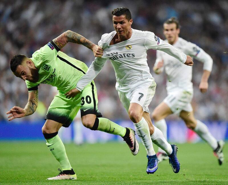Manchester City defender Nicolas Otamendi, left, tussles with Real Madrid's Cristiano Ronaldo. Javier Soriano / AFP