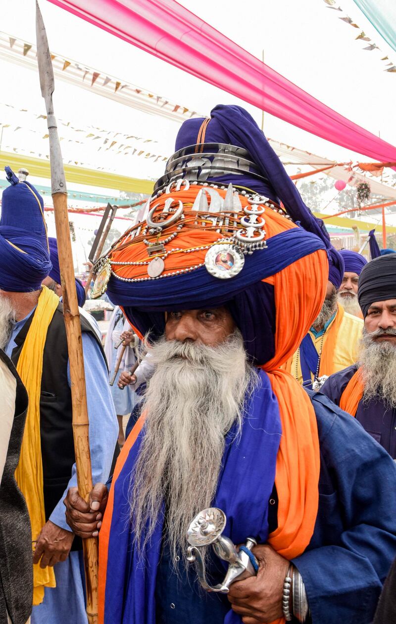 A Nihang (traditional Sikh religious warrior) wearing a giant turban pays his respect on the occasion of the 550th birth anniversary of Guru Nanak Dev at Gurudwara Ber Sahib in Sultanpur Lodhi. AFP