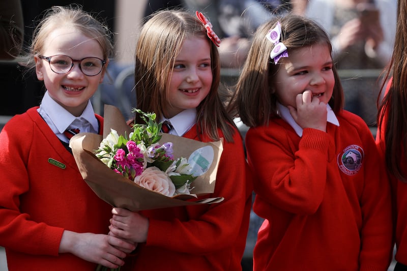 Children hold flowers as they await the couple's arrival. Reuters