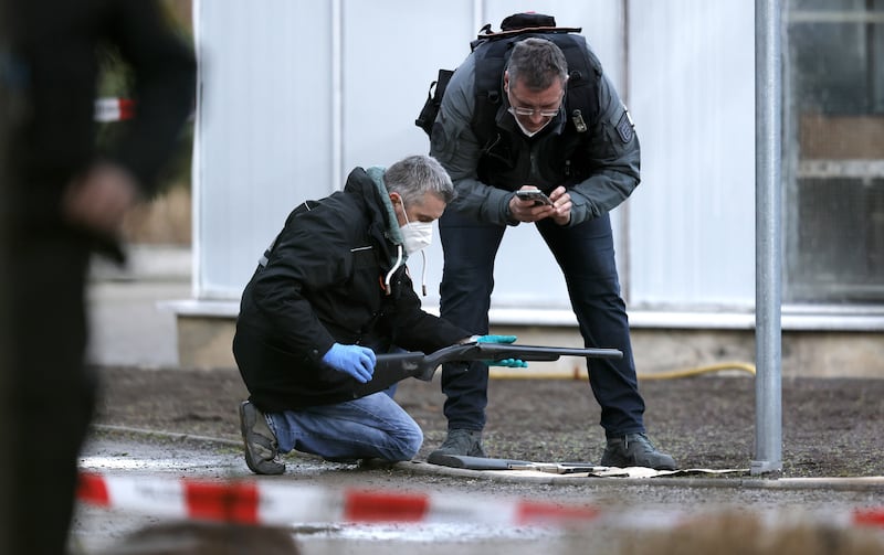 A police officer examines a weapon near the crime scene in Heidelberg. EPA