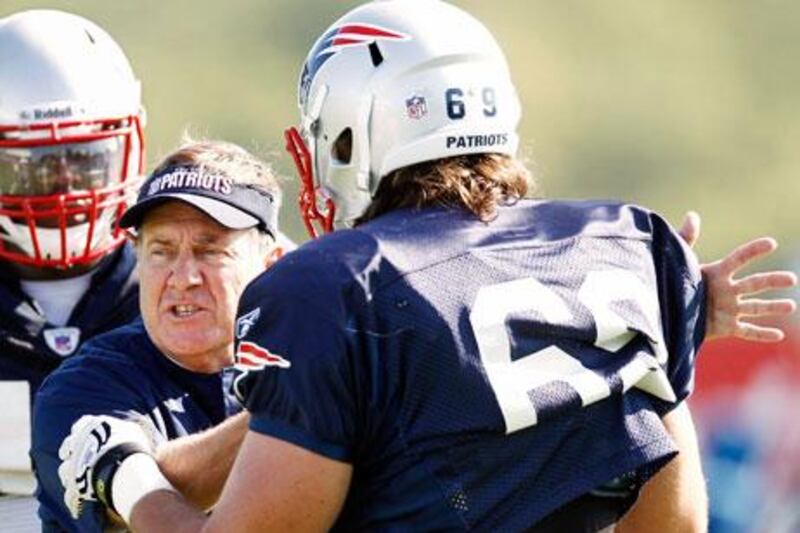 Bill Belichick, the New Engalnd Patriots head coach, gives hands on training to rookie defensive end Alex Silvestro during a recent training camp in Foxborough, Massachusettes.