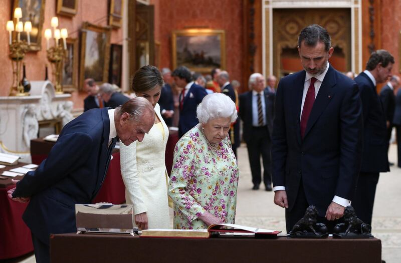 King Felipe VI (R) and Queen Letizia (2L) look at a display of Spanish items from the Royal Collection with Queen Elizabeth II (2R) and Prince Philip, Duke of Edinburgh (L), at Buckingham Palace. Neil Hall.