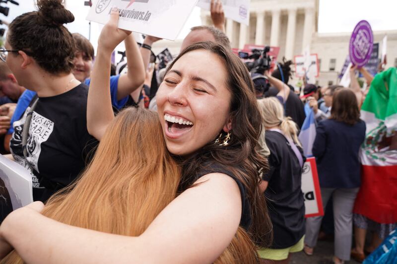 Pro-life supporters hug outside the court. AFP