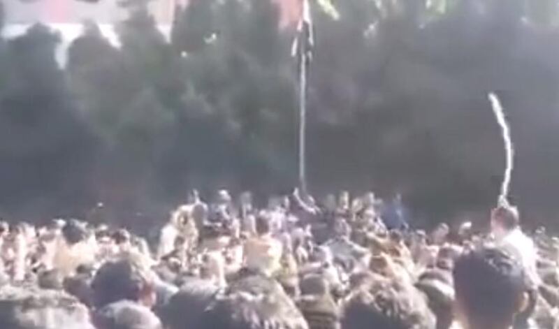 A screengrab from Yemen 24 which shows a group of students in Sanaa llistening to Houthi representatice. The students began to throw stones in the direction of the Houthi representatives and a man entered the scene with a stick and discplined some of the students.