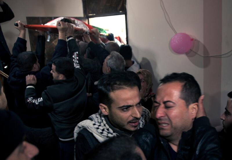 Relatives of 16-year-old Palestinian Mohammed Jahjouh, who was shot and killed by Israeli troops during a protest at the Gaza Strip's border with Israel, mourn as his body is carried into the family home. AP