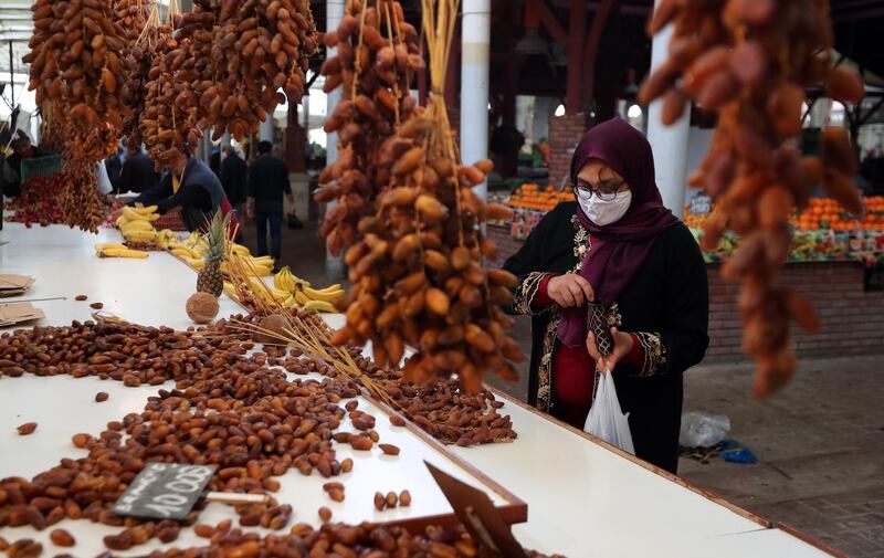 A Tunisian woman sells dates on the first day of Ramadan at a market in Tunis, Tunisia, 24 April 2020. EPA