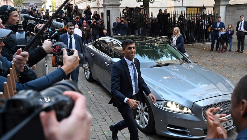 Rishi Sunak is greeted by colleagues upon his arrival. AFP