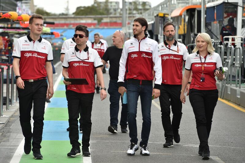 Alfa Romeo's Italian driver Antonio Giovinazzi (3rd R) walks down pit lane with team members at the Albert Park circuit ahead of the Formula One Australian Grand Prix in Melbourne.  AFP