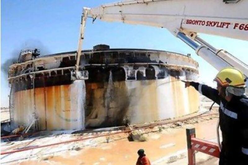 Libya's current instability is one factor keeping oil prices high, analysts say. Above, an oil tank in Brega set on fire by forces loyal to Muammar Qaddafi. EPA