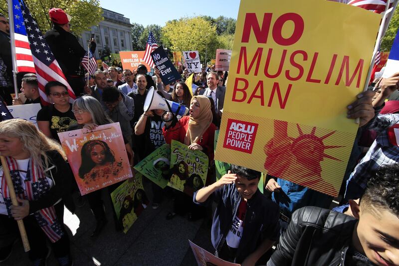 FILE - In this Oct. 18, 2017, file photo, protesters gather at a rally in Washington. The Supreme Court is allowing the Trump administration to fully enforce a ban on travel to the United States by residents of six mostly Muslim countries. The justices say in an order on Dec. 4, that the policy can take full effect even as legal challenges against it make their way through the courts. (AP Photo/Manuel Balce Ceneta, File)