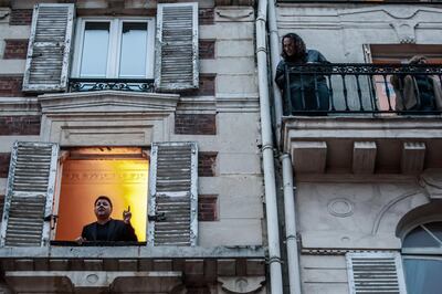 epa08312429 French tenor singer Stephane Senechal (L) sings at his window for the inhabitants of his street in Paris, France, 21 March 2020.  Senechal signs every evening since the beginning of containment measures decided by the government to lockdown France in an attempt to stop the widespread of the SARS-CoV-2 coronavirus causing the Covid-19 disease.  EPA/CHRISTOPHE PETIT TESSON