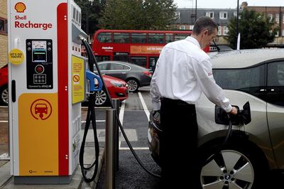 A member of staff charges an electric car at the Holloway Road Shell station where Shell is launching its first fast electric vehicle charging station in London, Britain October 18, 2017. REUTERS/Mary Turner - RC1503D26BA0