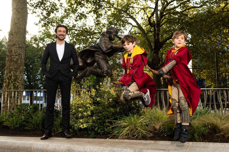 Presenter Alex Zanee and Harry Potter fans Finn and Joey Bruce celebrate during the unveiling of the new Harry Potter statue at Leicester Square. Getty Images