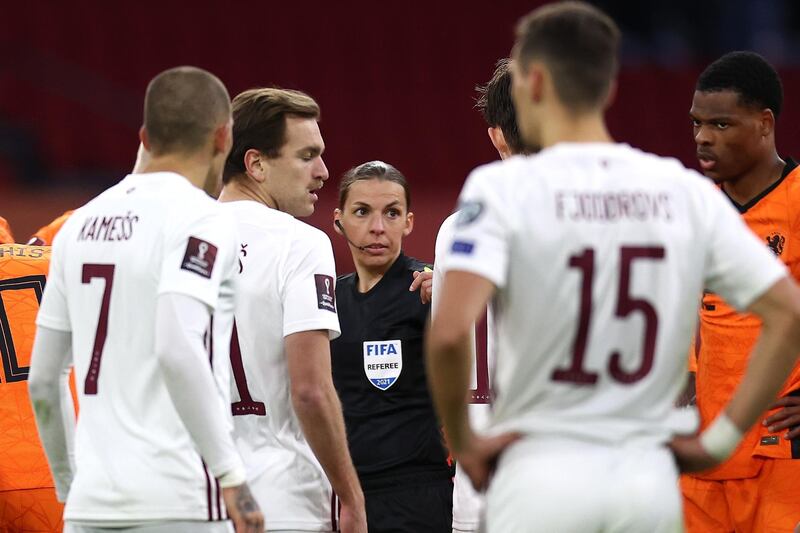 Referee Stephanie Frappart  talks to the players as the first women official to take charge of a World Cup qualifier. EPA Getty