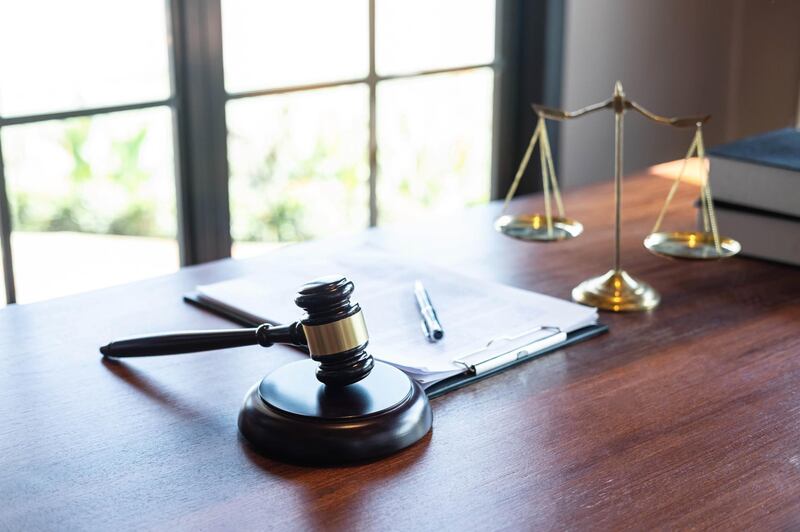 Judge gavel with Justice at law firm in background with legal case document contract, law and justice, attorney, lawsuit. Getty Images