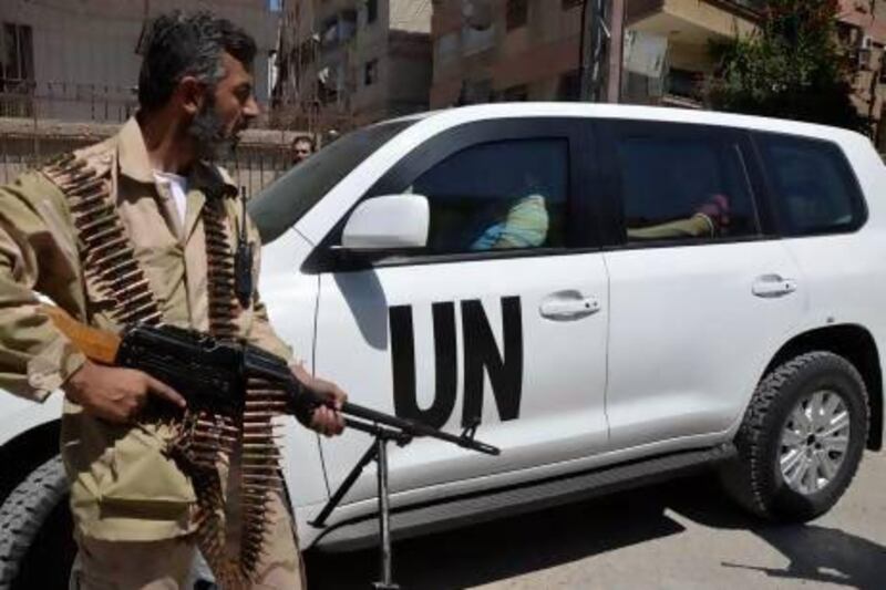 A Free Syrian Army fighter and fellow fighters escort a convoy of UN vehicles carrying a team of chemical weapons experts at a site of an alleged chemical weapons attack in Damascus.