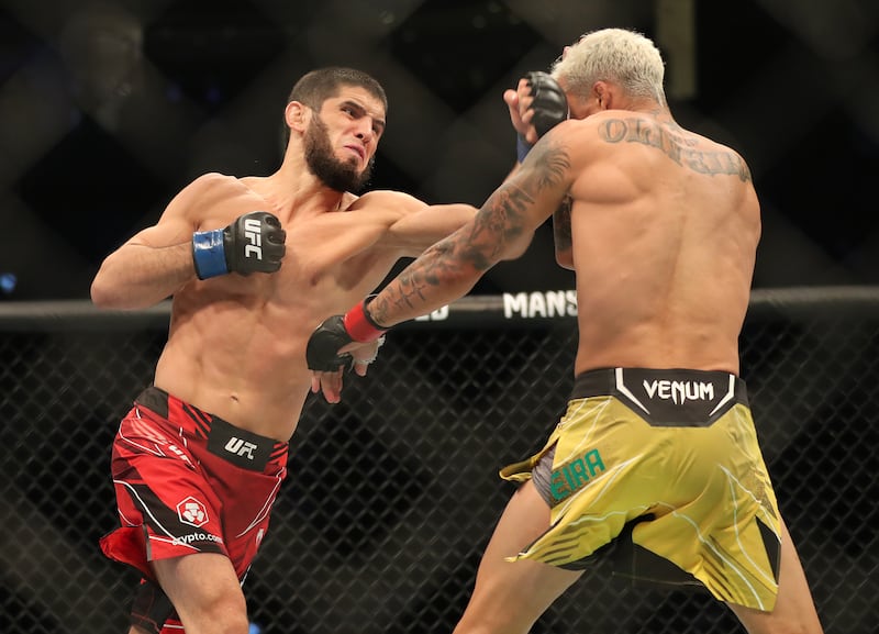 Islam Makhachev punches Charles Oliveira in their lightweight title fight at UFC 280 in Abu Dhabi. Chris Whiteoak / The National