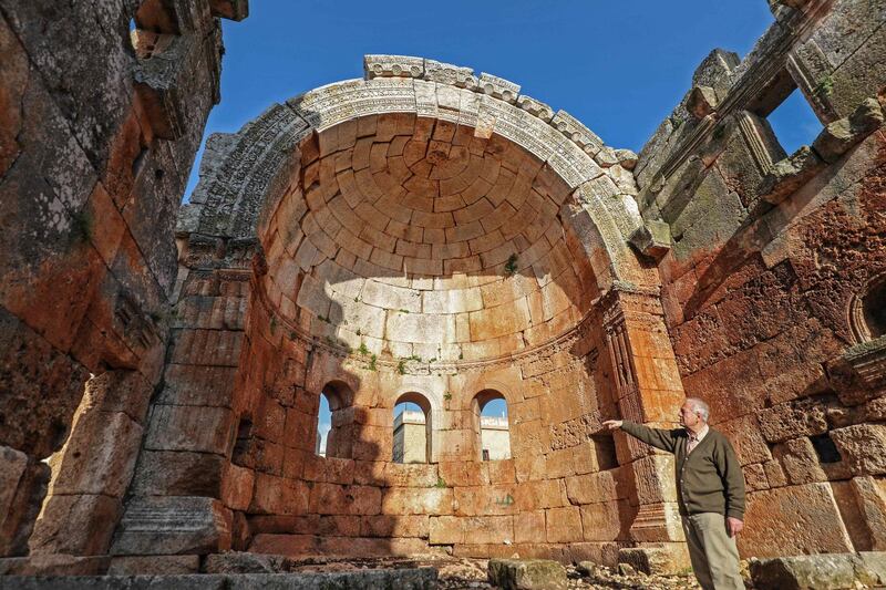 A man stands inside the apse of the 5th century basilica in Qalb Lozeh village in northwestern Syria, on April 18, 2019.  The ancient lime-stone cathedral is the architectural forerunner of France's famed Notre Dame cathedral. The abandoned church is widely hailed as Syria’s finest example of Byzantine-era architecture and is considered to have inspired Romanesque and Gothic cathedrals in Europe, including the Paris landmark.
 / AFP / OMAR HAJ KADOUR
