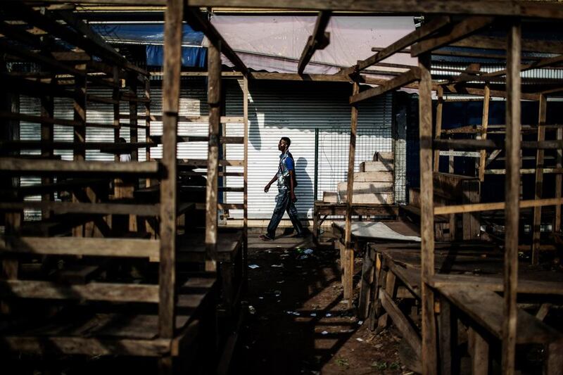 A man walks past empty stalls and closed shops during a “dead city” strike called by five defeated opposition candidates to protest the re-election of President Denis Sassou Nguesso, in Brazzaville, Congo. Marco Longari / AFP Photo