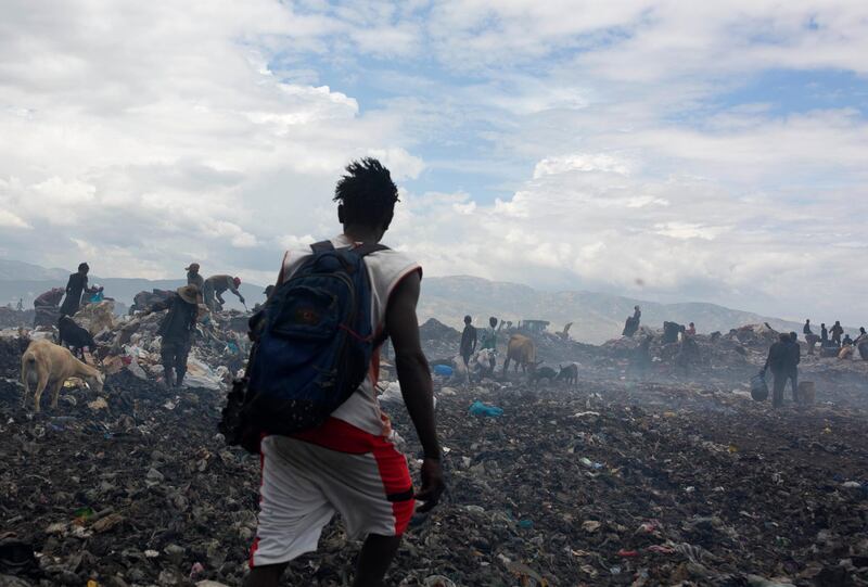 Changlair Aristide walks across the Truitier landfill wearing his soccer uniform after a day of scavenging for useful items to use or sell. AP Photo