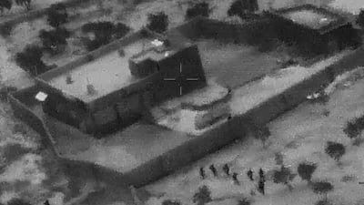 FILE - This Oct. 26, 2019, file image from video released by the Department of Defense, and displayed at a Pentagon briefing, shows U.S. Special Forces, figures at lower right, moving toward compound of Islamic State leader Abu Bakr al-Baghdadi. In his last months on the run, al-Baghdadi was agitated, fearful of traitors, sometimes disguised as a shepherd, sometimes hiding underground, always dependent on a shrinking circle of confidants. (Department of Defense via AP, File)