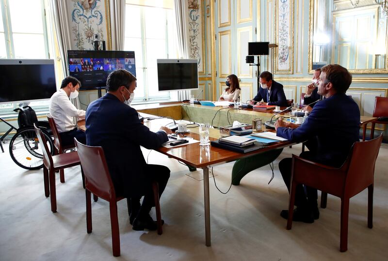 French President Emmanuel Macron, right, attends the virtual G7 meeting on the ongoing crisis in Afghanistan, at the Elysee Palace in Paris, Tuesday, August  24, 2021. AP