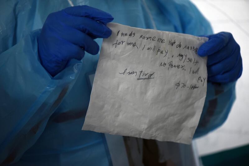 A healthcare worker shows his coworker a note written by a patient with the coronavirus disease (COVID-19) at United Memorial Medical Center in Houston, Texas. Reuters
