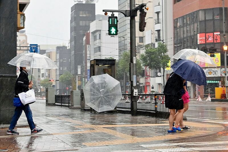 Pedestrians brave the bad weather in Matsuyama, Japan. AP