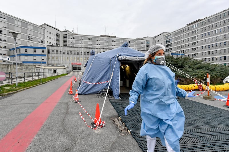 A paramedic walks out of a tent that was set up in front of the emergency ward of the Cremona hospital, northern Italy. AP