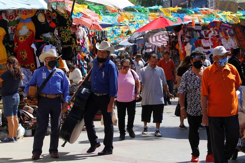 People, wearing masks, flock to the souvenir market in the city centre, Tijuana, Mexico. Reuters