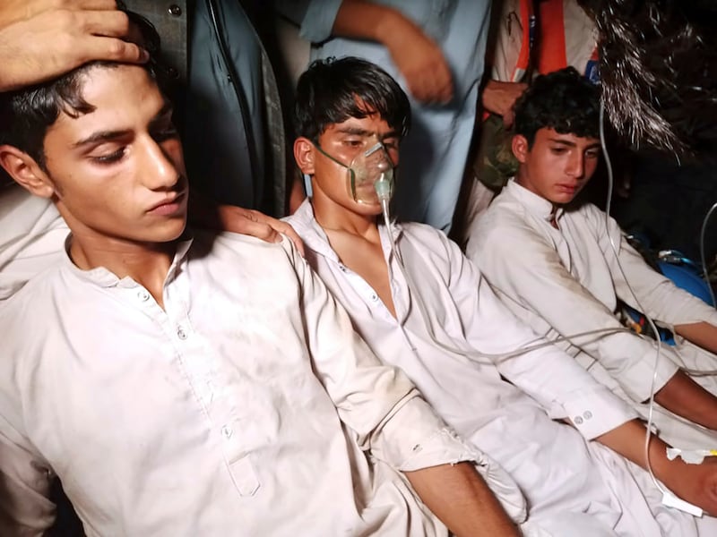 Youngsters, left, who were trapped in a broken cable car, receive first aid following their rescue, in Pashto village, a mountainous area of Battagram district in Pakistan's Khyber Pakhtunkhwa province, Tuesday, Aug.  22, 2023.  Army commandos using helicopters and a makeshift chairlift rescued eight people from a broken cable car dangling hundreds of meters (feet) above a canyon Tuesday in a remote part of Pakistan, authorities said.  (AP Photo / Nasir Mahmood)