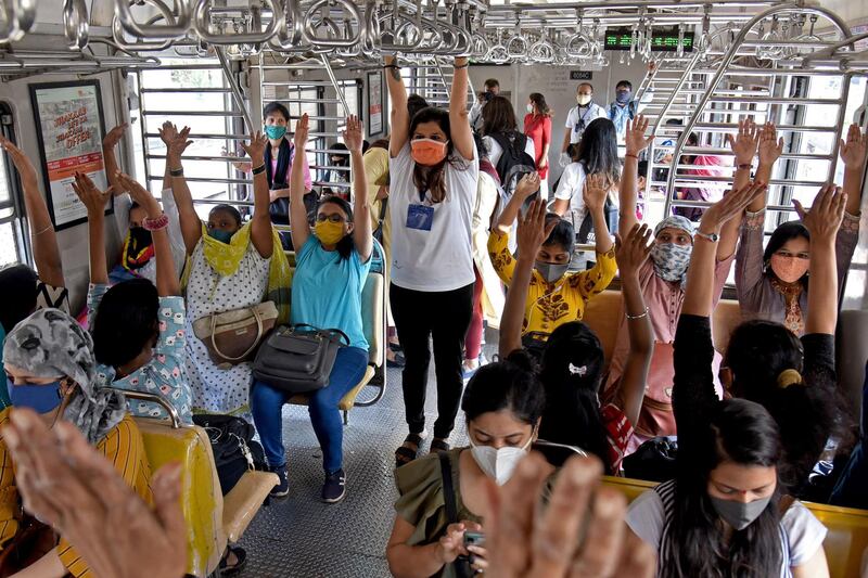 A yoga instructor teaches female passengers on a Mumbai train basic moves to celebrate International Women's Day. AFP