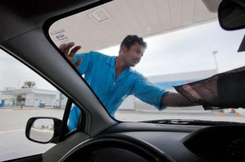 UAE - Sharjah - March 16- 2011:  A worker wash a car in a ADNOC petrol station. ( Jaime Puebla - The National Newspaper )