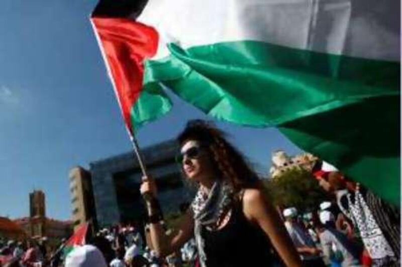 A protester carries a Palestinian flag in front of the United Nations headquarters in Beirut June 27, 2010. Several thousand Palestinians and Lebanese civil activists converged on central Beirut on Sunday, demanding more rights for Palestinians, many of whom live in squalid and over-crowded refugee camps in Lebanon. REUTERS/Khalil Hassan   (LEBANON - Tags: CIVIL UNREST POLITICS) *** Local Caption ***  LBN21_LEBANON-PALES_0627_11.JPG