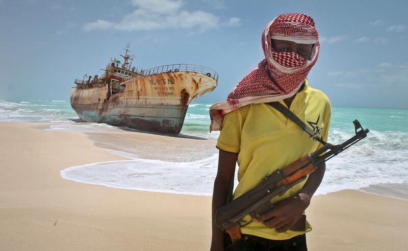 FILE - In this Sunday, Sept. 23, 2012 file photo, masked and armed Somali pirate Hassan stands near a Taiwanese fishing vessel washed ashore after the pirates were paid a ransom and the crew were released in the once-bustling pirate den of Hobyo, Somalia. Pirates have hijacked an oil tanker off the coast of Somalia, Somali officials and piracy experts said Tuesday, March 14, 2017, in the first hijacking of a large commercial vessel there since 2012. (AP Photo/Farah Abdi Warsameh, File)