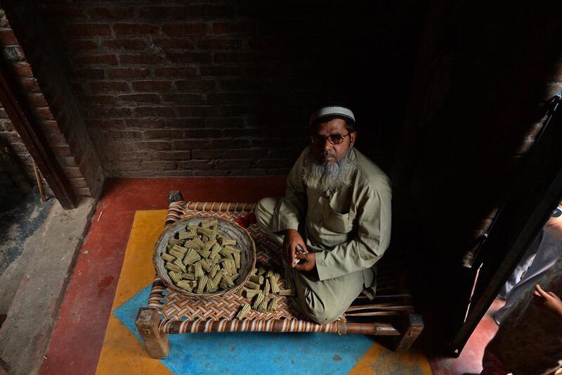 Muhammad Zaid, 50, looks on as he collects the bundles of bidis which he rolled, at his home in Kannauj.