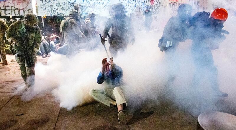 Federal officers use chemical irritants and crowd control munitions to disperse Black Lives Matter protesters in Portland. AP