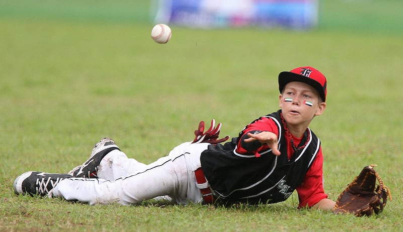 Clarke Philippines, July 3 2013, Asian Pacific Little League Playoffs, Paul Radley Story-UAE All Star Sam Page Fields a ground ball after diving over the bag .The UAE and Philippines game was rain soaked making playing conditions difficult for both teams. Philippines out scored the UAE 13-7 and the UAE remains winless for the Playoffs. Mike Young For the National  