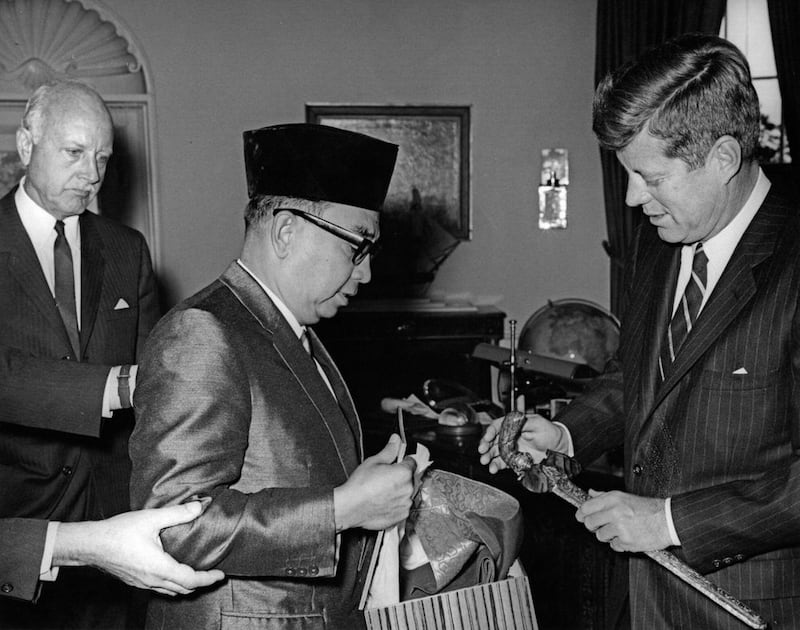 2EC32GC Meeting with Tun Abdul Razak, Deputy Prime Minister of Malaya, 11:58AM. President John F. Kennedy exchanges gifts with Deputy Prime Minister and Minister of Defense of Malaya, Tun Abdul Razak Hussein (center left), during a meeting in the Oval Office. U.S. Ambassador to Malaya, Charles F. Baldwin, stands at far left. White House, Washington, D.C. Alamy