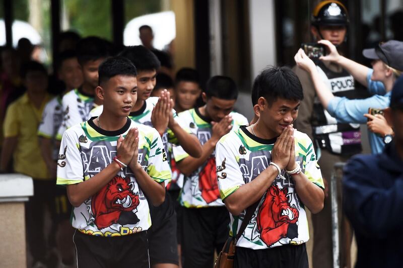 Some of the twelve Thai boys, rescued from a flooded cave after being trapped, arrive to attend a press conference in Chiang Rai on July 18, 2018, following their discharge from the hospital. The young footballers and their coach appeared healthy when they appeared before the media for the first time on July 18. / AFP / Lillian SUWANRUMPHA
