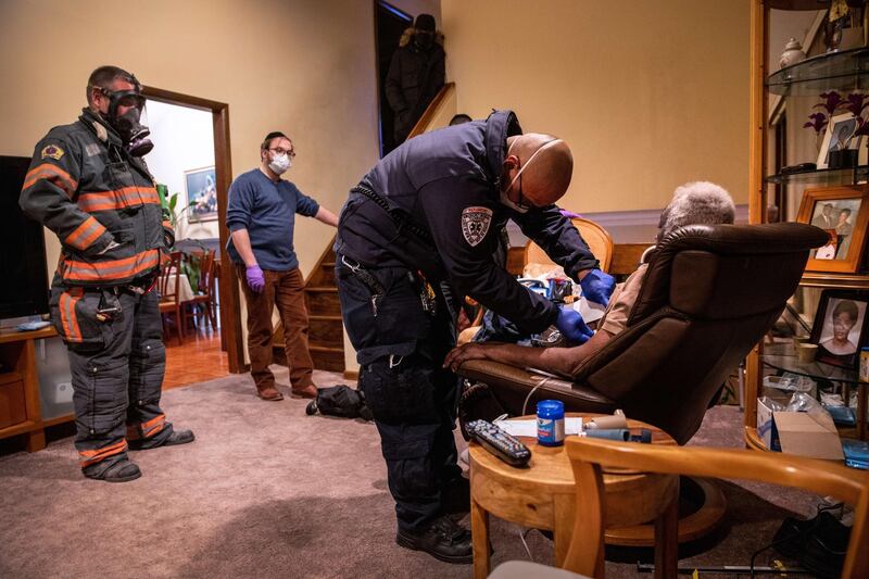 YONKERS, NEW YORK - DECEMBER 15: (EDITORIAL USE ONLY) Empress EMS Cpt. AJ Briones assesses a potential COVID-19 patient before transporting him to a hospital on December 15, 2020 in Yonkers, New York. As the coronavirus pandemic surges nationwide, hospitals have begun vaccinating healthcare workers with the Pfizer/BioNTech COVID-19 vaccine.   John Moore/Getty Images/AFP
== FOR NEWSPAPERS, INTERNET, TELCOS & TELEVISION USE ONLY ==
