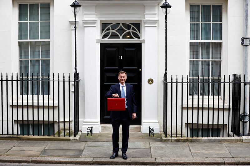 Mr Hunt holds the budget box in Downing Street. Reuters