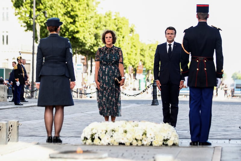 French President Emmanuel Macron stands next to British ambassador to France Menna Rawlings, after rekindling the flame under the Arc de Triomphe in Paris to mark the British queen's platinum jubilee. Reuters