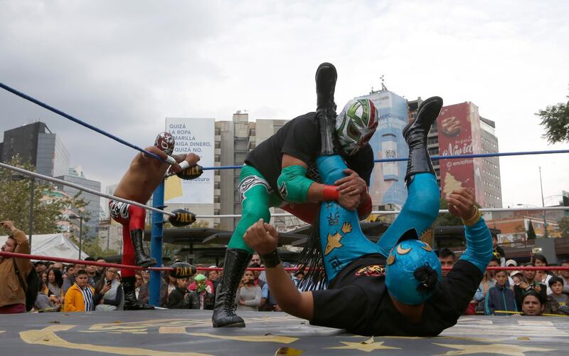 Mexican wrestler Rakner clashes with Relampago Veloz during a "lucha libre" fight in Mexico City, on Saturday, December 21. AP